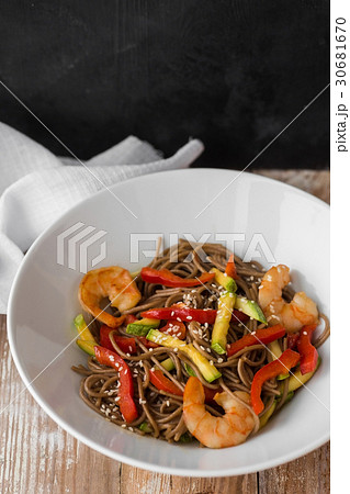 Noodles with vegetables and seafood on a wooden 30681670