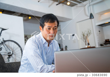 パソコンを見る中年男性　ミドル世代　中高年　短髪の男性　カジュアル　普段着　男の人 30683690