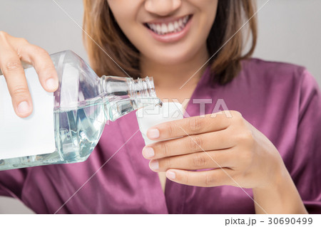 Woman Using Mouthwash After Brushing Woman Using Mouthwash After Brushing 30690499