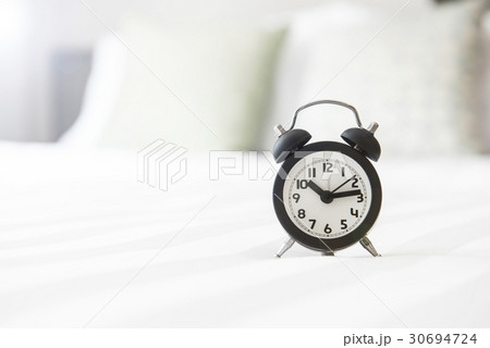 Alarm clock on the bed and time to wake up 30694724