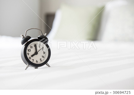 Alarm clock on the bed and time to wake up 30694725