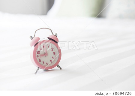 Alarm clock on the bed and time to wake up 30694726