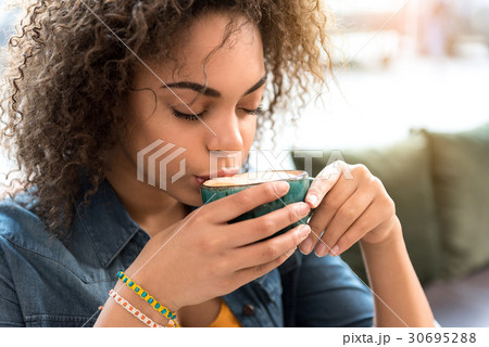 Glad woman tasting cup of beverage Glad woman tasting cup of beverage 30695288