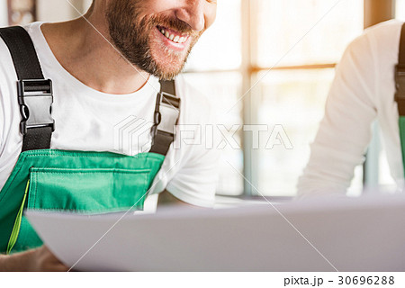 Happy smiling builder keeping plan 30696288