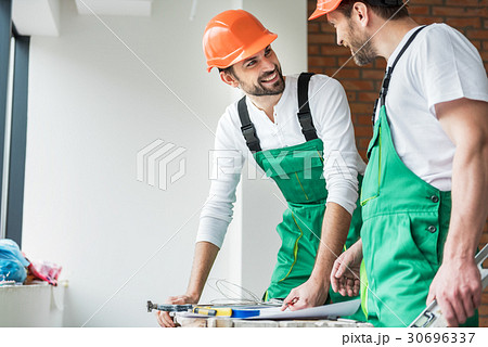 Happy smiling constructors working together 30696337