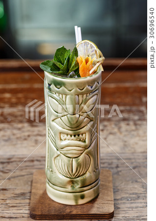 Refreshing summer cocktail in a tiki glass Refreshing summer cocktail in a tiki glass 30696540