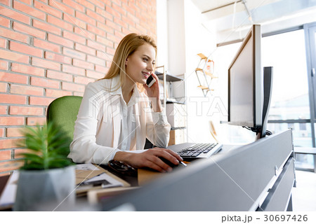Charming girl sitting on her workplace with smile Charming girl sitting on her workplace with smile 30697426