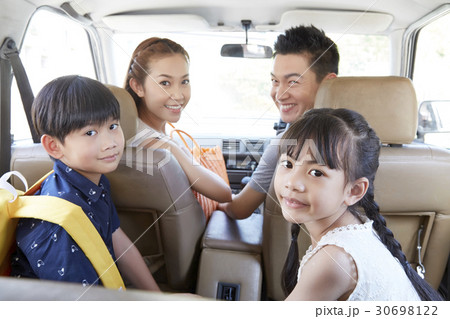 Four members of a family is travelling together on holiday. 30698122