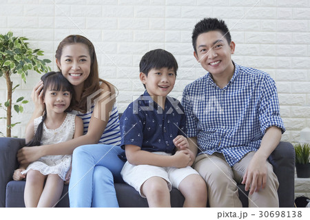 a happy family is resting on the sofa. a happy family is resting on the sofa. 30698138