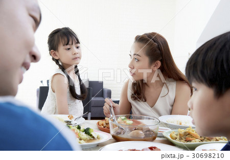 Mother, daughter and others are talking while eating a meal together. Mother, daughter and others are talking while eating a meal together. 30698210