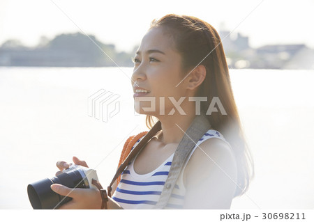 Beautiful girl is holding the camera and sightseeing. 30698211