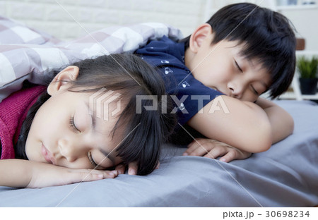 Cute siblings are sleeping in bed. Cute siblings are sleeping in bed. 30698234