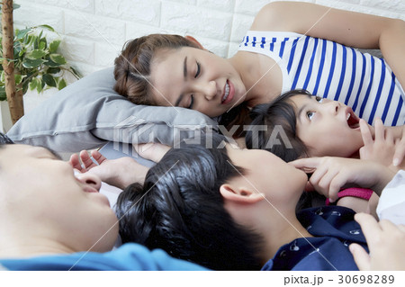 a family of parents and two children lying and sleeping 30698289