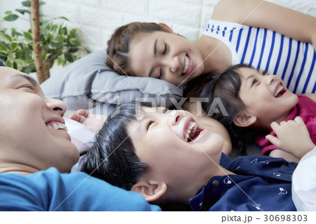 a family of parents and two children is lying and smiling 30698303