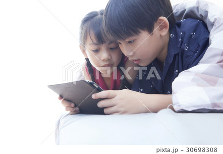 a photo of two kids watching an ipad 30698308