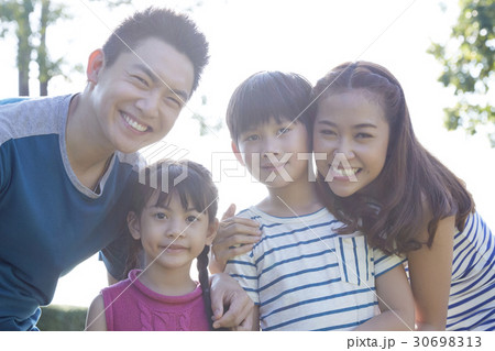 a portrait of a happy family of parents and two children smiling 30698313