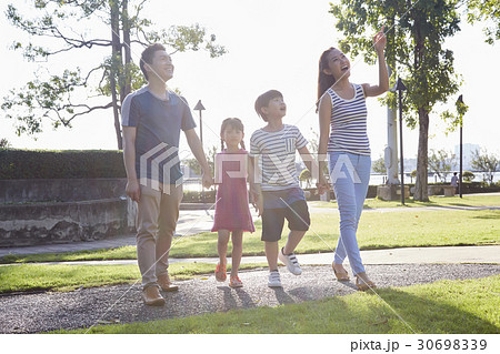 a family of four people is sightseeing and looking at something. a family of four people is sightseeing and looking at something. 30698339