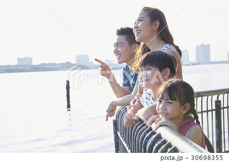 A couple and two children are smiling and viewing on a riverside. A couple and two children are smiling and viewing on a riverside. 30698355