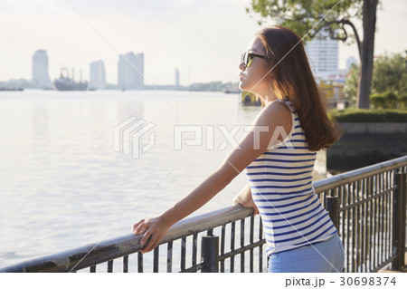 The left side of a girl standing and viewing sunrise on a riverside 30698374