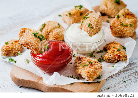 Fried nuggets dipped into two sauces 30698523
