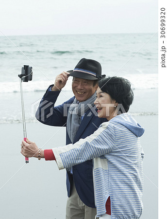 海岸で自撮りするシニア夫婦の写真素材