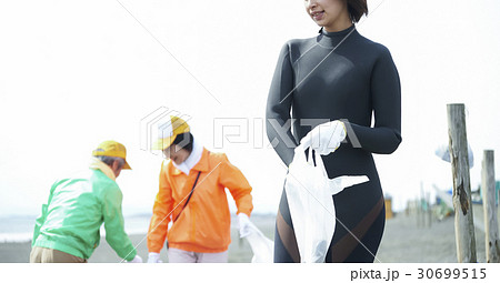 ビーチクリーンをするシニアボランティアとサーファー 30699515