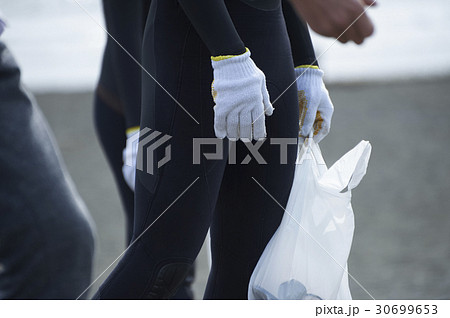 ビーチクリーンをするシニアボランティアとサーファー 30699653