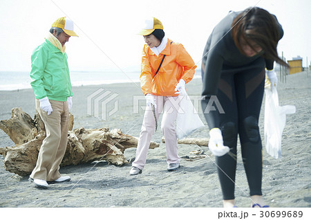 ビーチクリーンをするシニアボランティアとサーファー 30699689