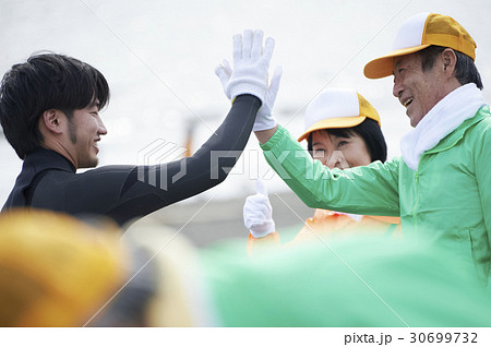 ビーチクリーンをするシニアボランティアとサーファー 30699732