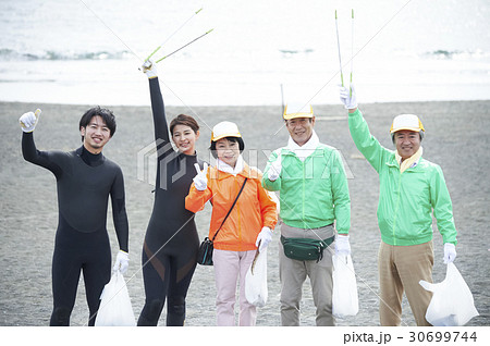 ビーチクリーンをするシニアボランティアとサーファー 30699744