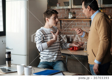 Shocked boy putting himself right with his father 30703393