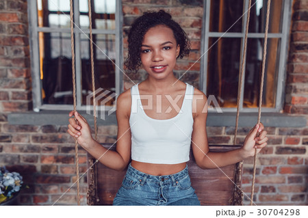 Beautiful african girl in white tops sitting on a Beautiful african girl in white tops sitting on a 30704298