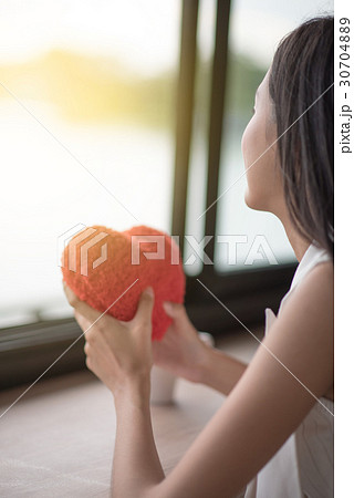 Beautiful young woman with fluffy heart pillow Beautiful young woman with fluffy heart pillow 30704889