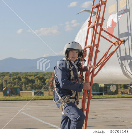 Military pilot in helmet stands near jet plane Military pilot in helmet stands near jet plane 30705143