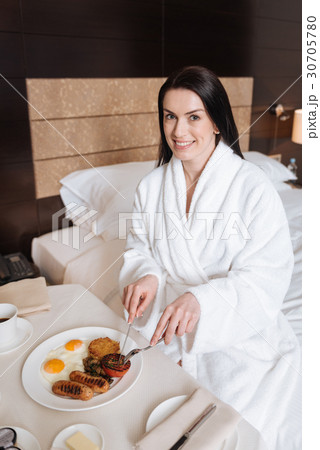 Happy positive woman using a knife and fork Happy positive woman using a knife and fork 30705780