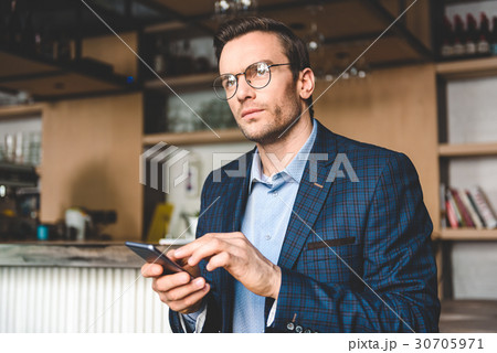 Pensive man sending sms in confectionary shop 30705971