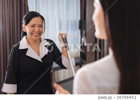 Happy positive chambermaid looking at her manager 30706952