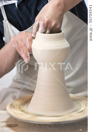 Potter makes pottery handmade in the workshop  30709541