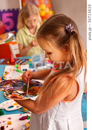 Small students girl painting in art school class. 30713619