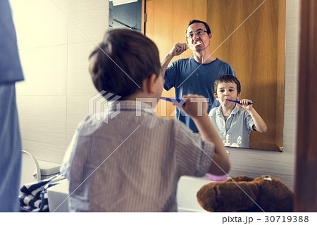 Father teaching the son how to brush his teeth 30719388