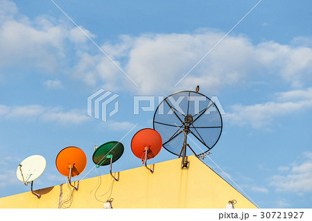 Several satellite dish installed on the house roof with blue sky Several satellite dish installed on the house roof with blue sky 30721927