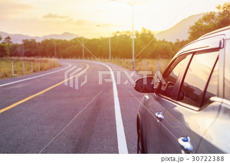 Back side of new silver SUV car parking on the asphalt road in sunset time 30722388