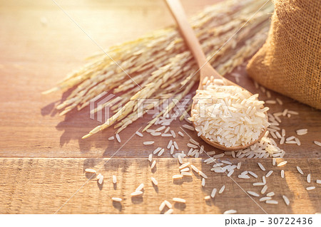 Thai jasmine rice in spoon and small sack on wooden table background 30722436