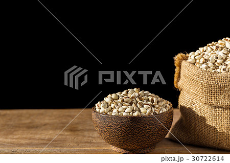 Close up millet rice or millet grains in bowl on wooden table. Isolated on black Close up millet rice or millet grains in bowl on wooden table. Isolated on black 30722614