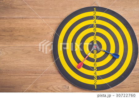 Dart arrow and dartboard on brown wooden background. Composition white free space for text or design 30722760
