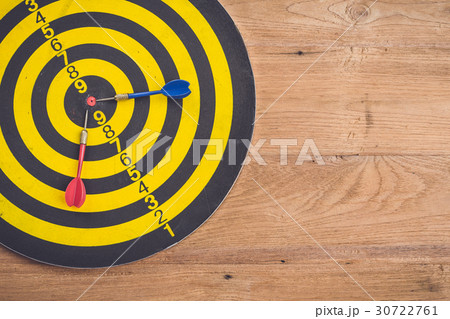 Dart arrow and dartboard on brown wooden background. Composition white free space for text or design 30722761