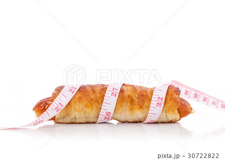 Sausage bread and measurement tape. Studio shot isolated on white. Junk food, obesity or food healthy concept Sausage bread and measurement tape. Studio shot isolated on white. Junk food, obesity or food healthy concept 30722822