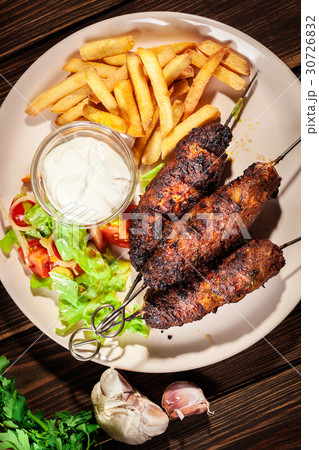 Grilled shish kebab served with fried chips 30726832