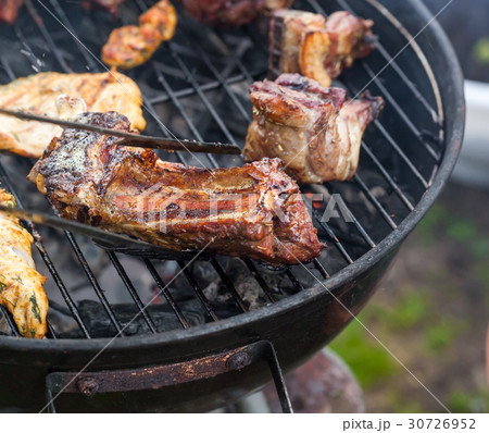 Cooking grilled red meat on barbeque 30726952