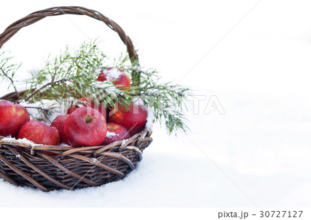 Red apples in basket in snow, outside 30727127